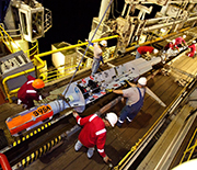 Scientists and engineers on ship, readying instruments for an expedition.